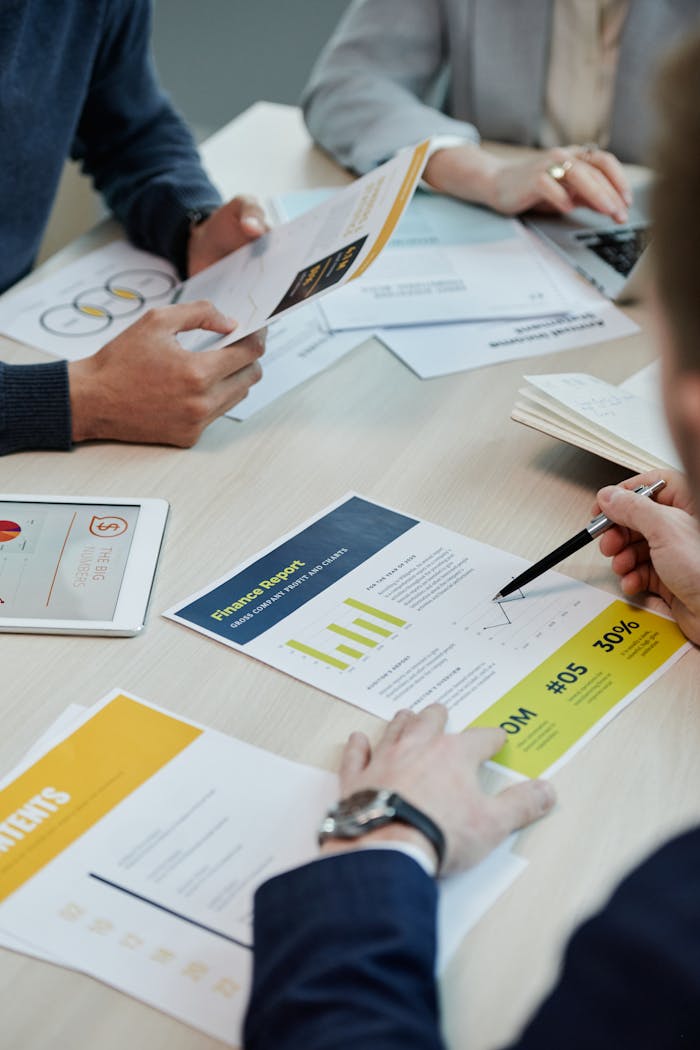 Professionals working together in an office, analyzing financial reports and documents with focus on graphs and teamwork.